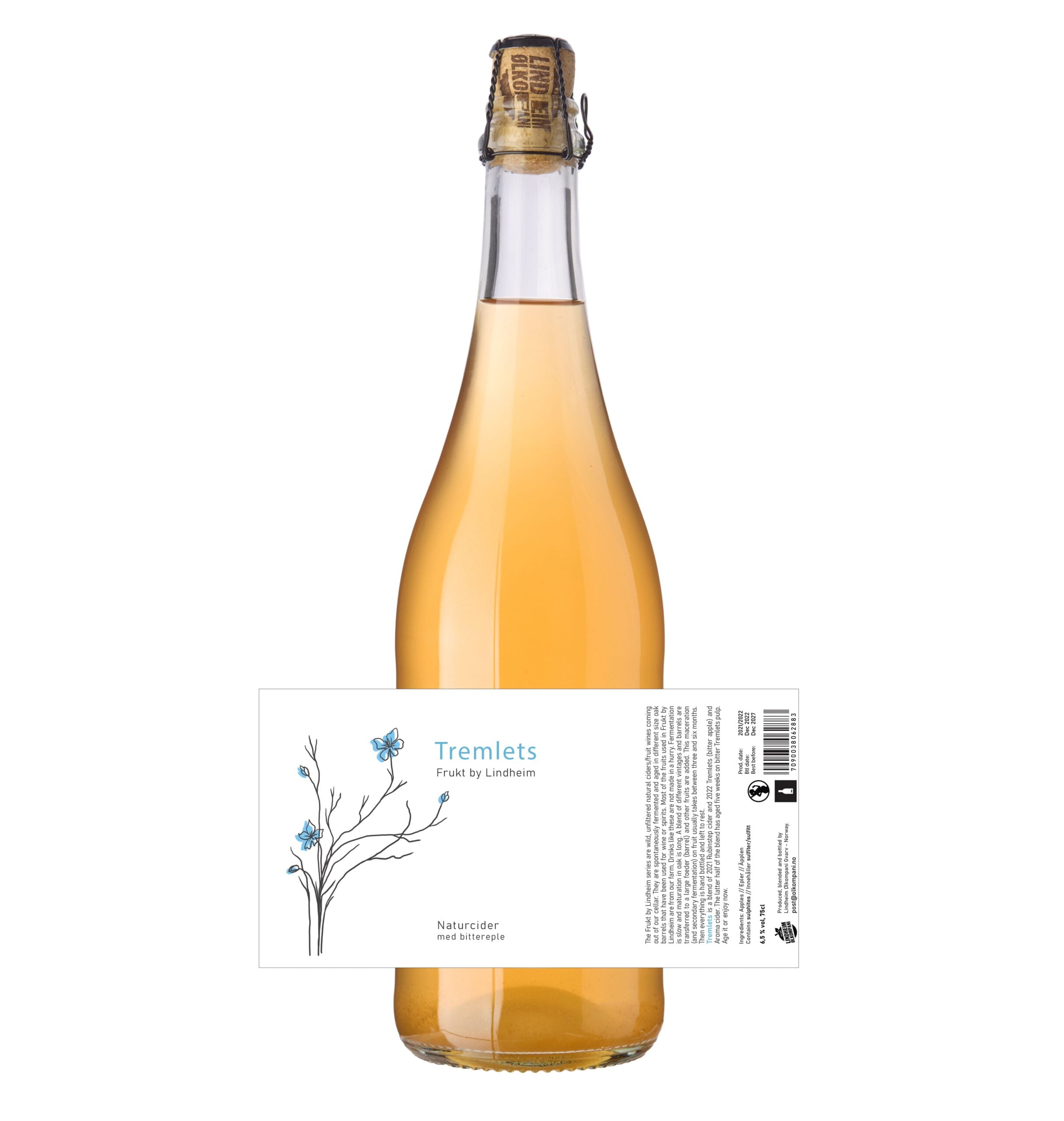 Alt-tekst: Flaske med Tremlets naturcider fra Lindheim, med kunstnerisk etikett og lett gyllen farge.
